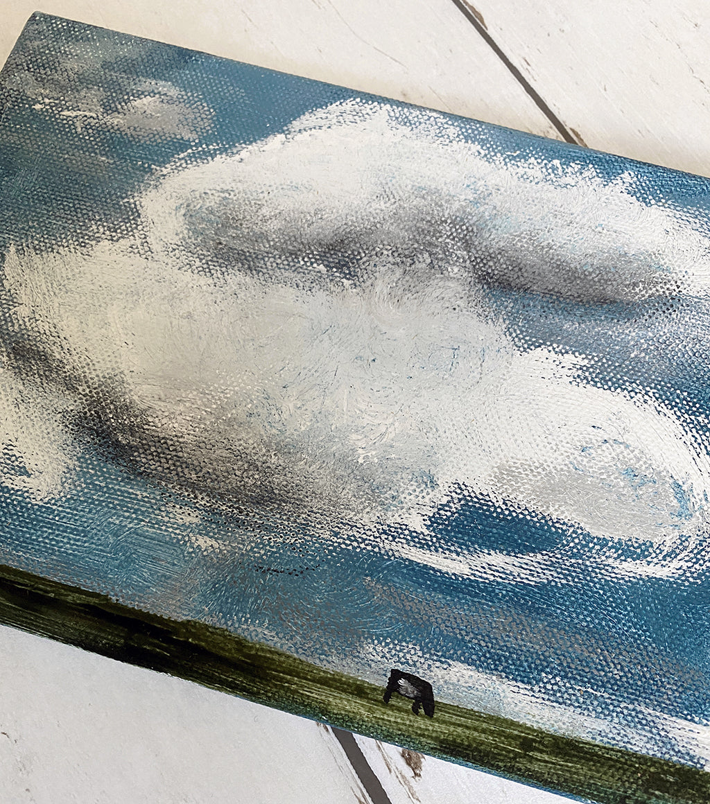 roundy clouds with 1 cow & grass